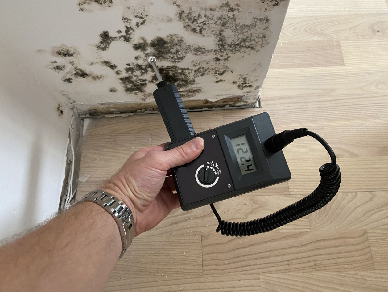 Fugtmålinger af en væg med synlig skimmelsvamp. I displayet står der 122,4. SBi-anvisning 281, BUILD, Aalborg Universitet